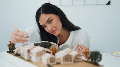 Closeup of beautiful architect measure the architectural model. Immaculate.