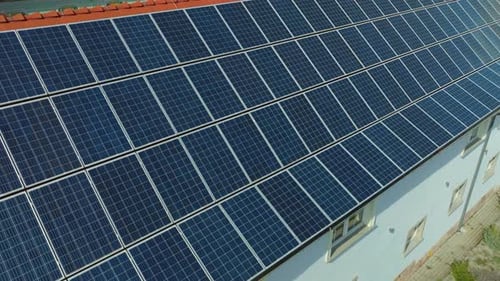 Sunlight drenches a vast array of solar panels atop a building, hinting at a sustainable energy futu