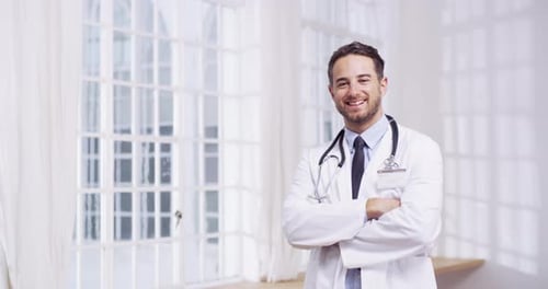 4k video of a young male doctor standing in a hospital