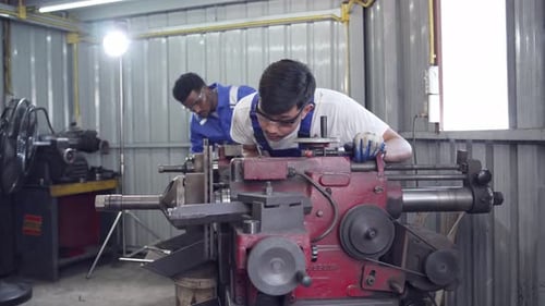 Two Men Working on Metal Fabrication Machinery