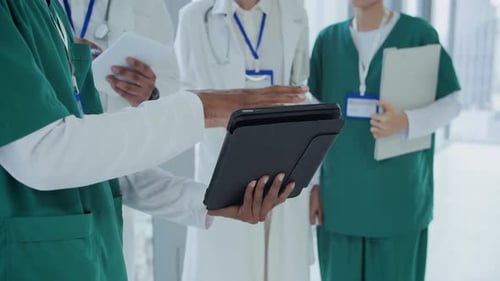 Medical Team Reviewing Data on Tablet in Hospital