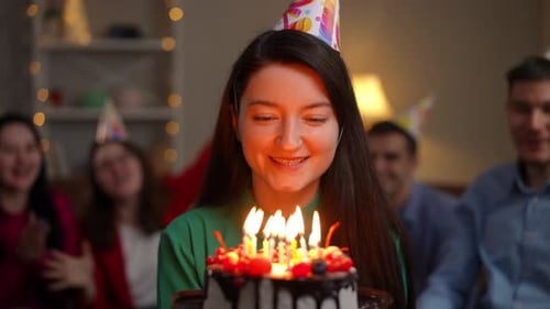 Happy Woman Blows Out Birthday Candles With Friends