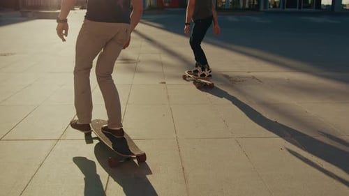 Two Professional Skaters Riding on Skateboards Through Fashionable Hipster District. Handsome Guy S
