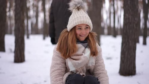 Charming Pretty Teen Girl Looking at Camera Smiling Sitting on Sled As Boy Start Walking Pulling