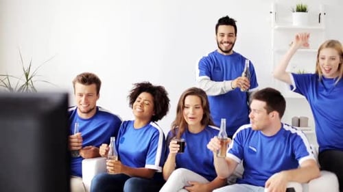 Enthusiastic friends cheer watching TV at home