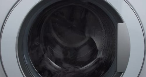 Laundry load mid-cycle wet spin drum close-up