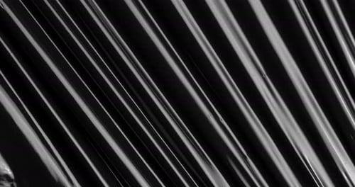 Discover an Otherworldly Fusion of Textures As Stretched Plastic Film Weaves Across a Black Expanse