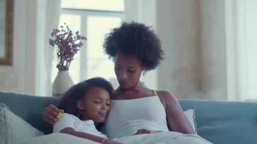 Mother and Child Hugging on Couch Indoors