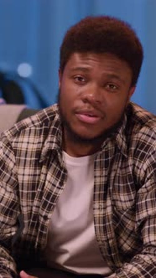 A Young Man Deep in Thought and Reflection While Relaxing on a Couch in a Casual Setting