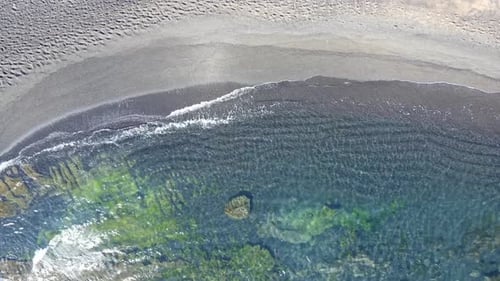 Ocean waves and black beach top view, natural background.
