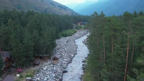 Aerial View of a River Running Through a Forested Mountain Valley