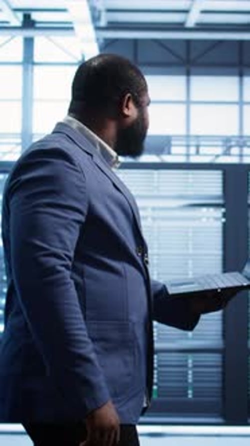 Man Using Laptop in Modern Server Room