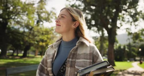 Happy woman, student and walking with books in park for learning, education or path to university