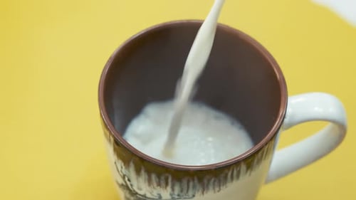 Pouring Hot Milk Into Mug. closeup shot