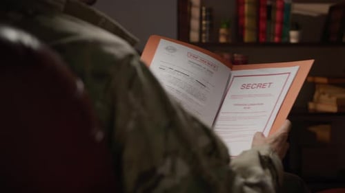 Person Reading Top Secret Documents in Folder