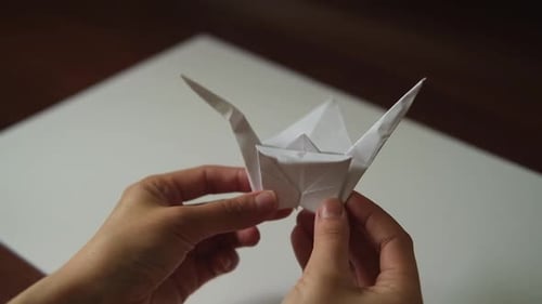 Einen Origami aus Papier falten, Nahaufnahme eines weißen Kranichs