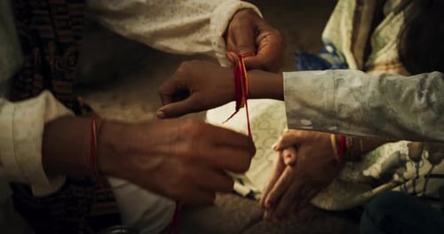 Close Up Authentic Footage of Hindu Priest Tying a Mauli Thread Around a Male Kid's Wrist in