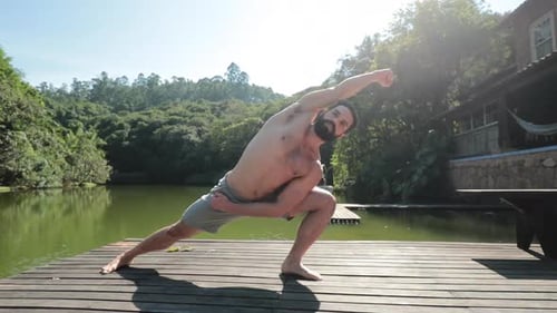 Fit man stretching body and strengthening muscles in Yoga pose outdoors