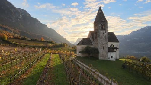 Aerial Drone Over a medieval church in the middle of the Vineyards in Autumn in South Tyrol.