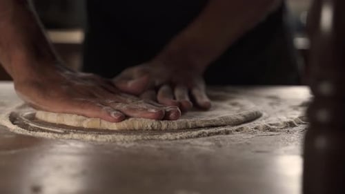 4K Male chef kneading homemade pizza dough on wooden table 2