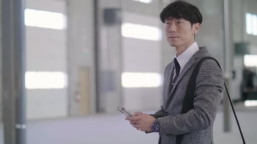 Male Inspector With Smart Phone In Empty Warehouse Slow Motion