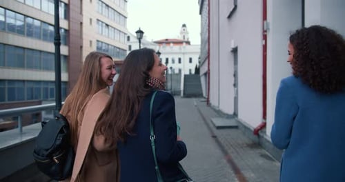 Three Friends Walking Down Urban Street Talking