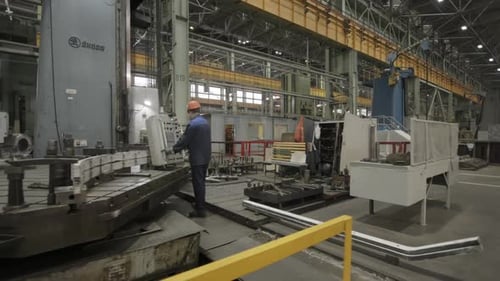 Man Operating Machinery in Industrial Factory Setting