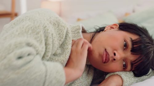 Young Woman Resting Peacefully in Bed at Home