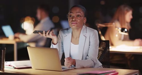 African American Attractive Office Manager Using Laptop Computer Talking on the Phone Performing