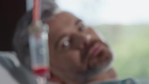 In Hospital Room Shot of Blood Transfusion on Background Man Lying in Modern Clinic Donation Blood