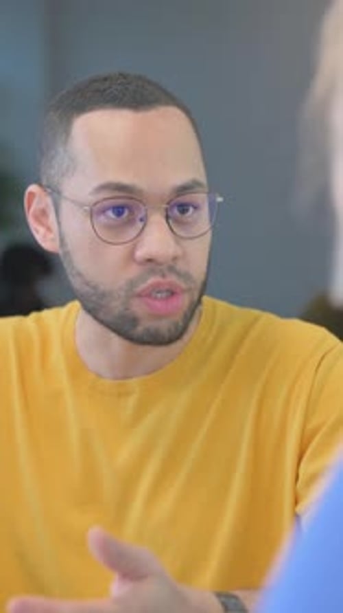 Mixed Race Man Talking with Young Woman in Office, vertical video