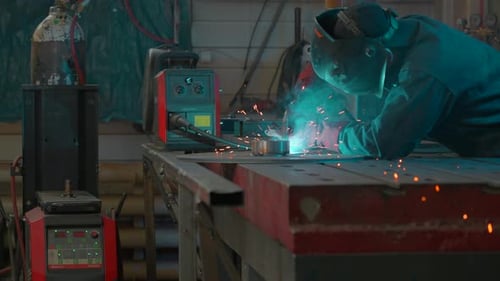 Man Welding Metal in Workshop