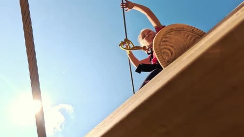 Happy Little Girl Playing in Tarzan Attraction on Playground in Amusement Park. Little Girls Enjoy P