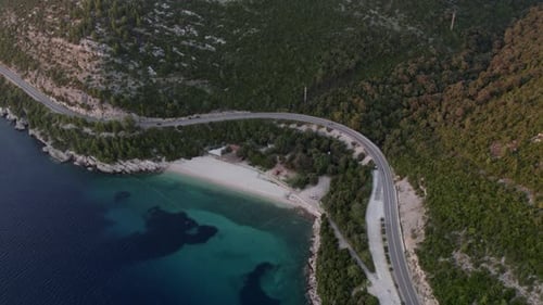 Aerial view of beach, road, mountain by Adriatic Sea at sunset, Croatia.