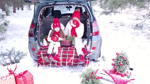 Family - mother and daughter cheerfully celebrate Christmas in the forest