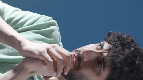 Vertikales Video eines schizophrenen jungen Mannes, der zu Hause verrückt wird, Anfälle und Halluzinationen hat.