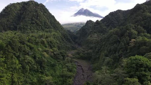 Beautiful view of Mount Merapi in the morning between the green hills. The mountain is in Yogyakara,