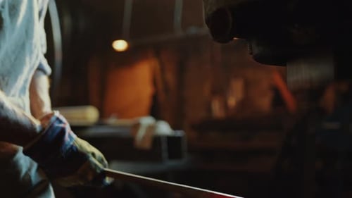 Man Forging Hot Metal with Industrial Machine Press