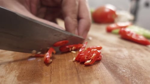 Close-up of slicing hot chili peppers on a cutting board