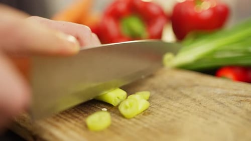 Nahaufnahme des Schneidens von frischem Chili-Pfeffer auf einem Schneidebrett