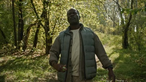 Mature Tourist Applying Mosquito Repellent on Clothes Hiking on Forest Trail
