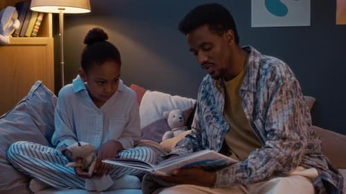 Dad Reads Story to Child at Bedtime