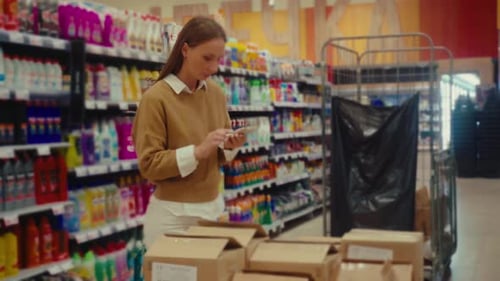 Store Employee Organizes Packages While Managing Inventory at Retail Location