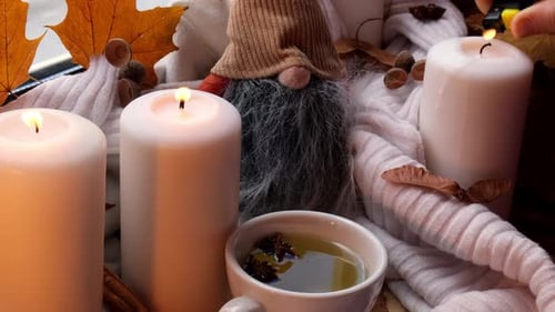 Lighting Candles in Autumn Scene with Tea