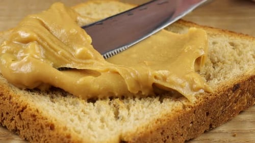 Spreading Creamy Peanut Butter on Delicious Toast