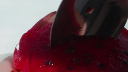 Half a red pitahaya, dragon fruit, I eat the pulp with a spoon. Dolly slider extreme close-up. Laowa