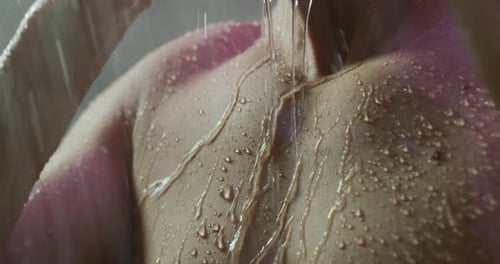 Close up of an young handsome man is taking a hot relaxing shower in a luxury wellness center.