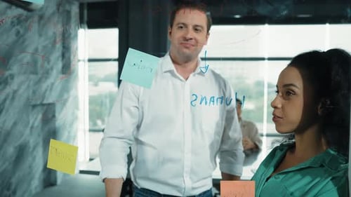 Team Brainstorming on Glass Whiteboard in Modern Office