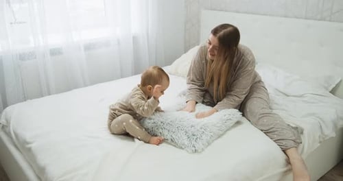 Mother and Child Playing on Bed Together