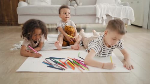Three Children Drawing Together Indoors At Home